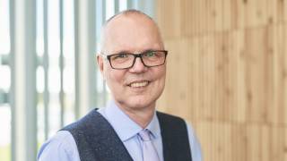 Informaatioteknologian ja viestinnän tiedekunnan dekaani Jyrki Vuorinen katsoo hymyillen kameraa kohti.