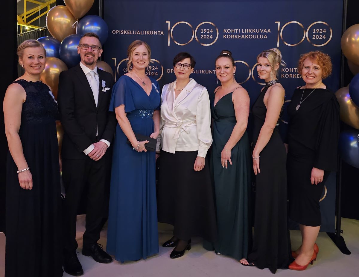 OLL 100-vuotisjuhlassa SportUnin tiimiä ja Tampereen yliopiston vararehtori Marja Sutela (kesk,). 