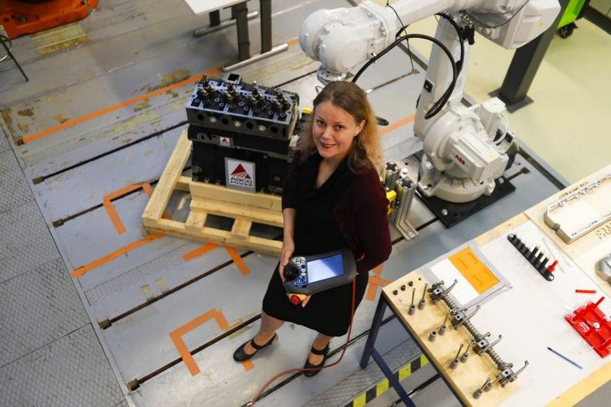 Hymyilevä nainen tekniikan laboratoriossa.