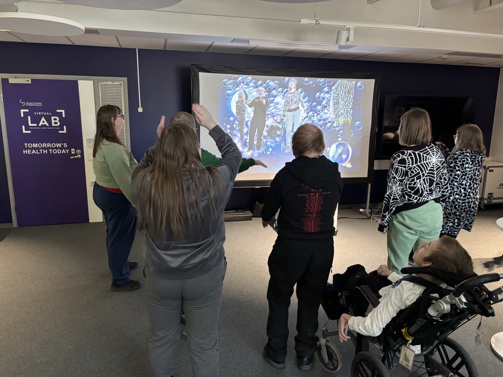 Kuvassa taikaseinää pelaava ryhmä