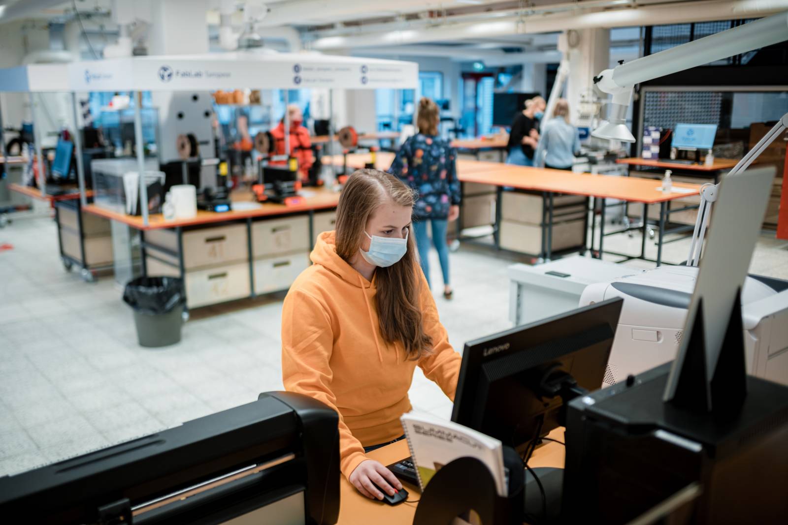 Henkilöitä työskentelee FabLabin tilassa.