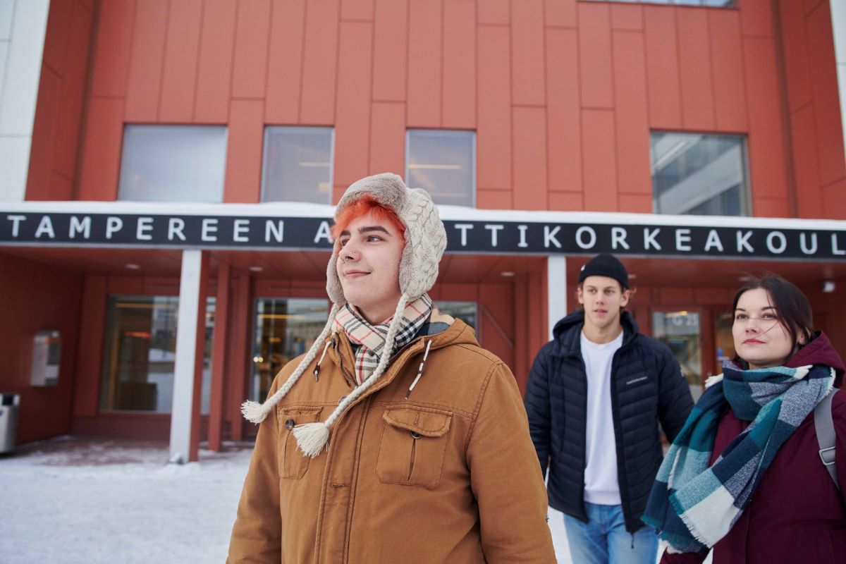 Three young men outside in a campus during winter time.