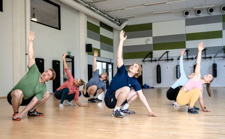 Ryhmä ihmisiä venyttelee.