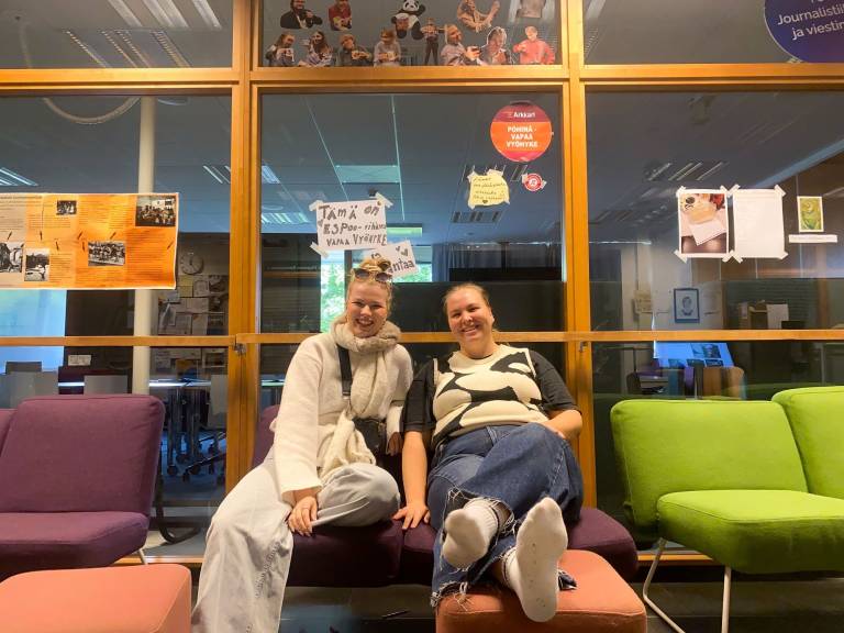 Kaksi opiskelijaa istuu luokkatilan sohvalla yliopistolla.