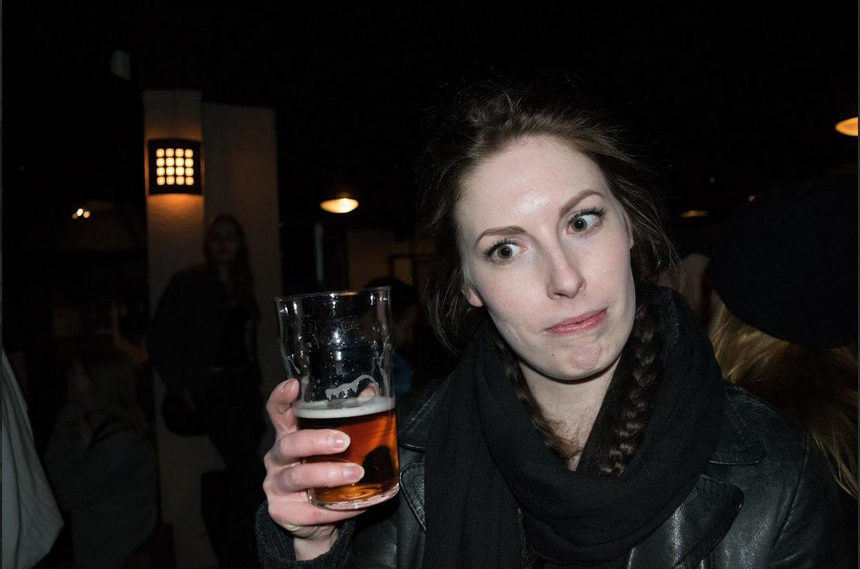 Kuvassa nainen oluttuoppi kädessä.