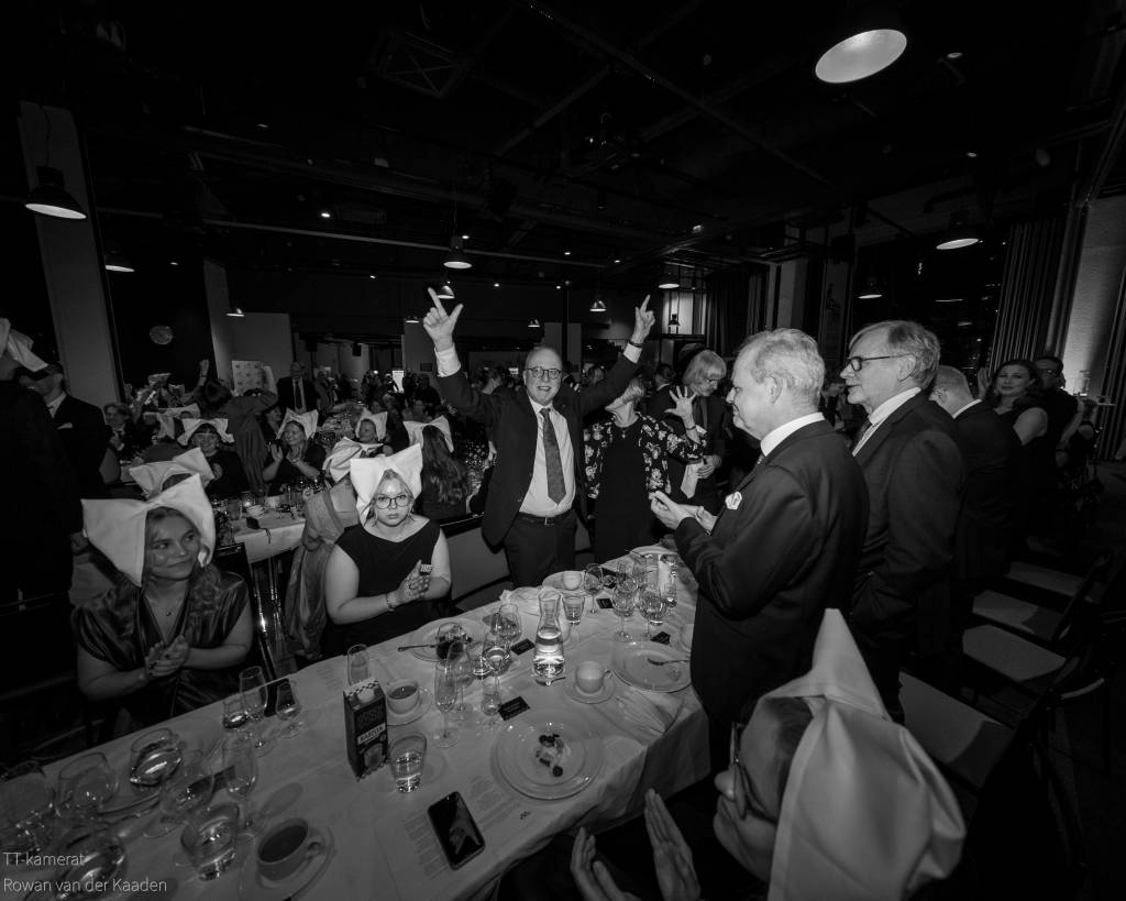 Juhliva väkijoukko juhlapöydässä.