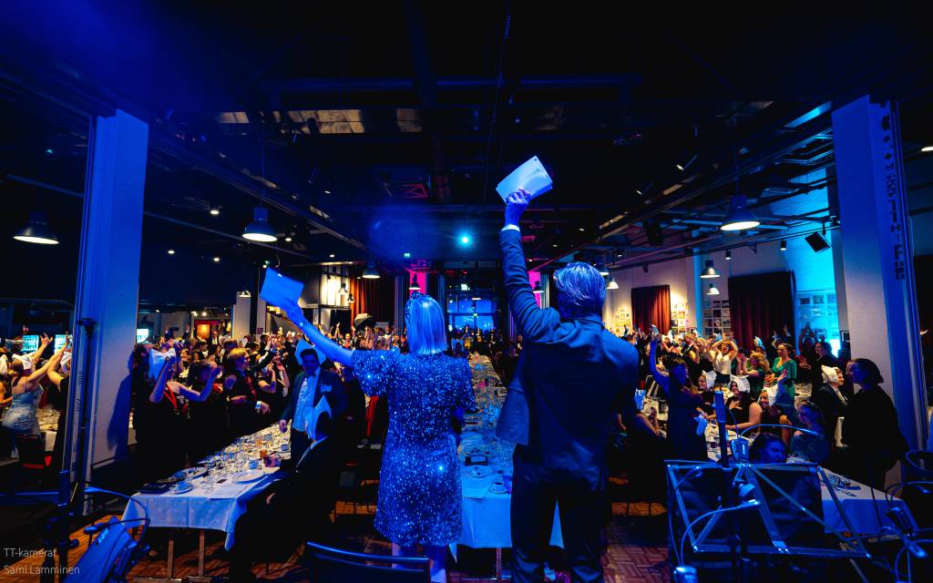 Juhlan juontajat lavalla selin kameraan päin.