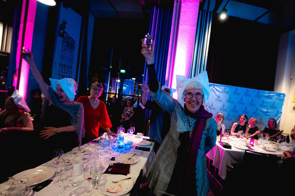 Nainen nostaa juhlamaljan.