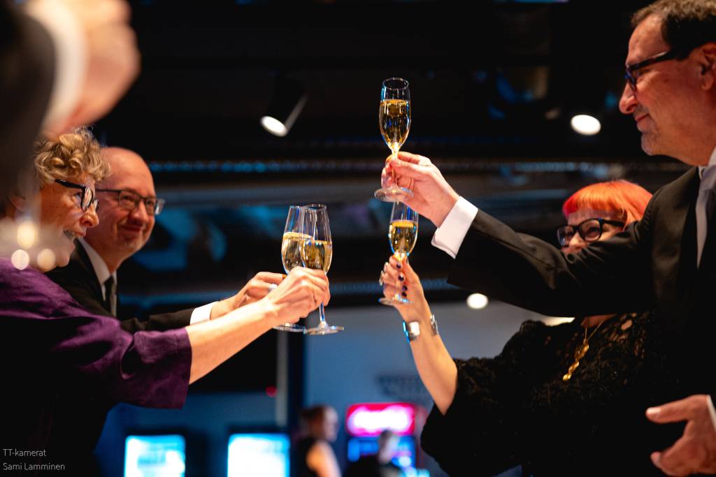Pöytäseurue nostaa juhlamaljoja.