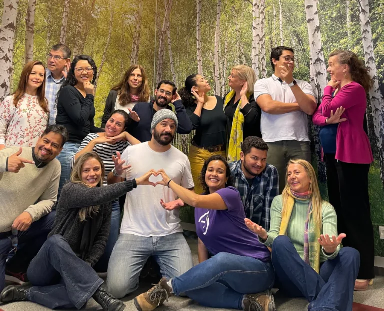 16 people in a portrait smiling and having dialogue