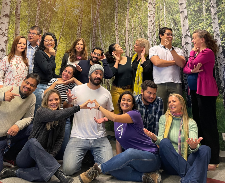 16 people in a portrait smiling and having dialogue