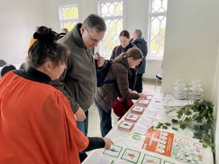 Tiimiläisiä pöydän ääressä tarkastelemassa taukotarroja.