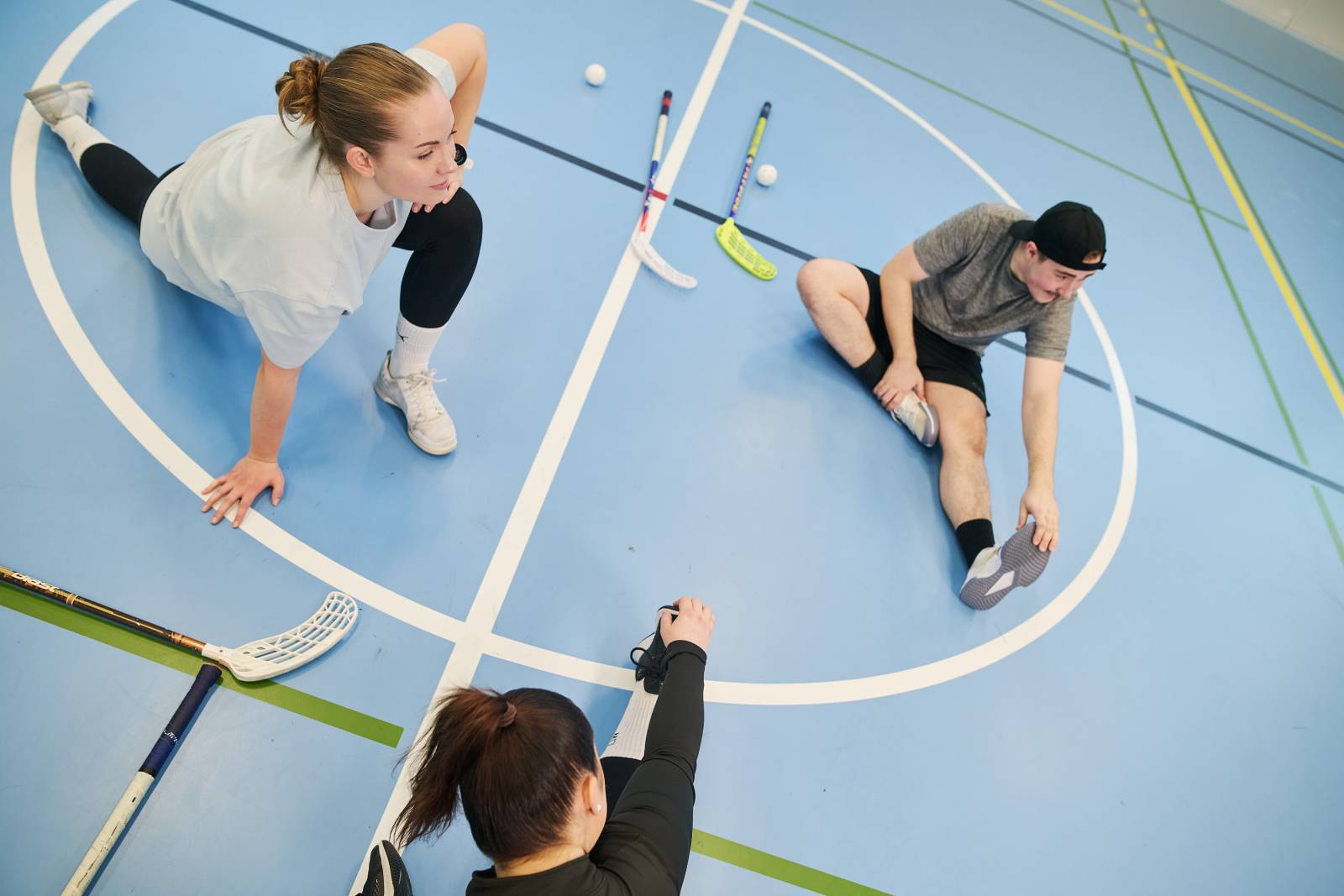 Opiskelijoita palloiluhallissa venyttelemässä.