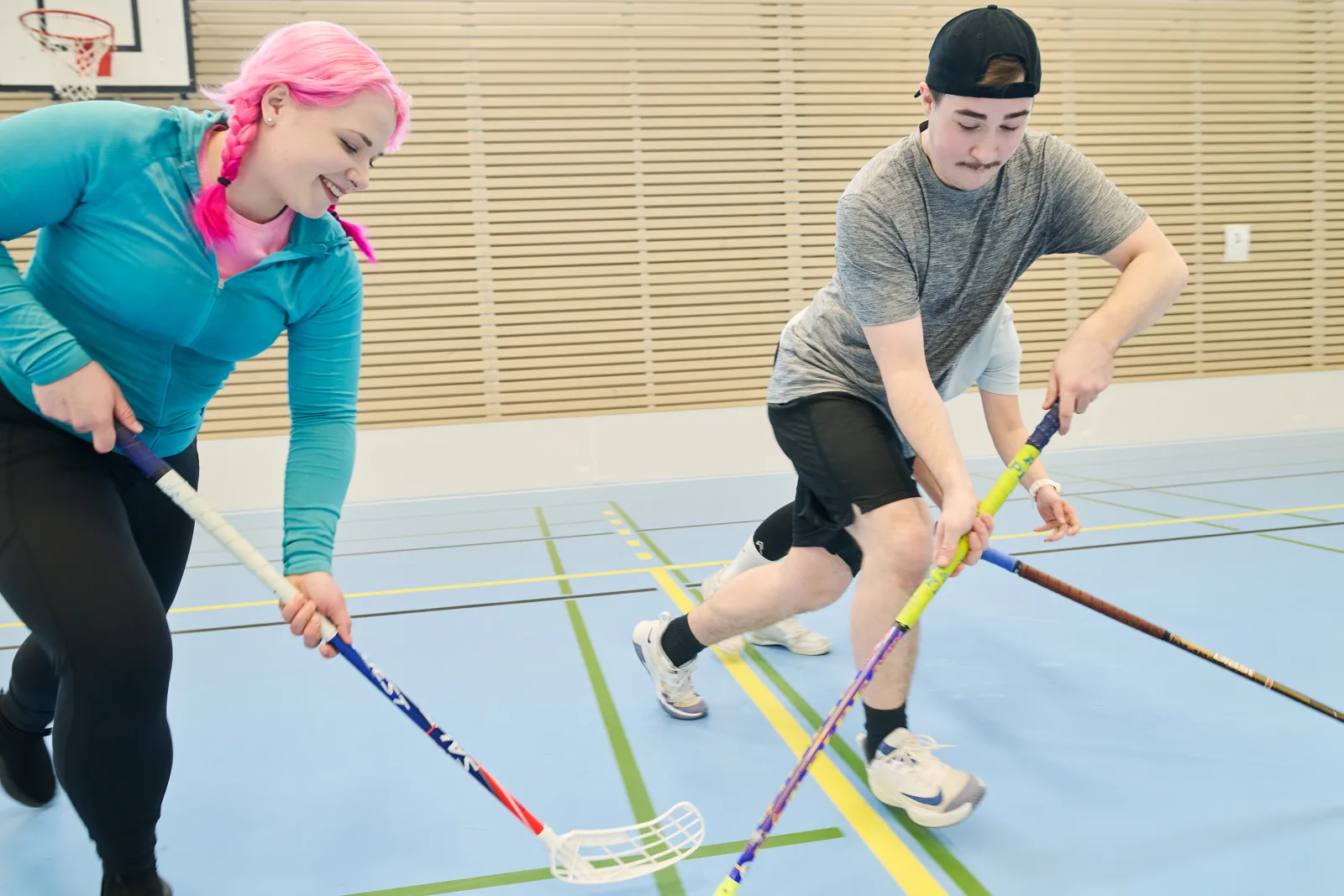 Opiskelijat pelaavat salibandya.