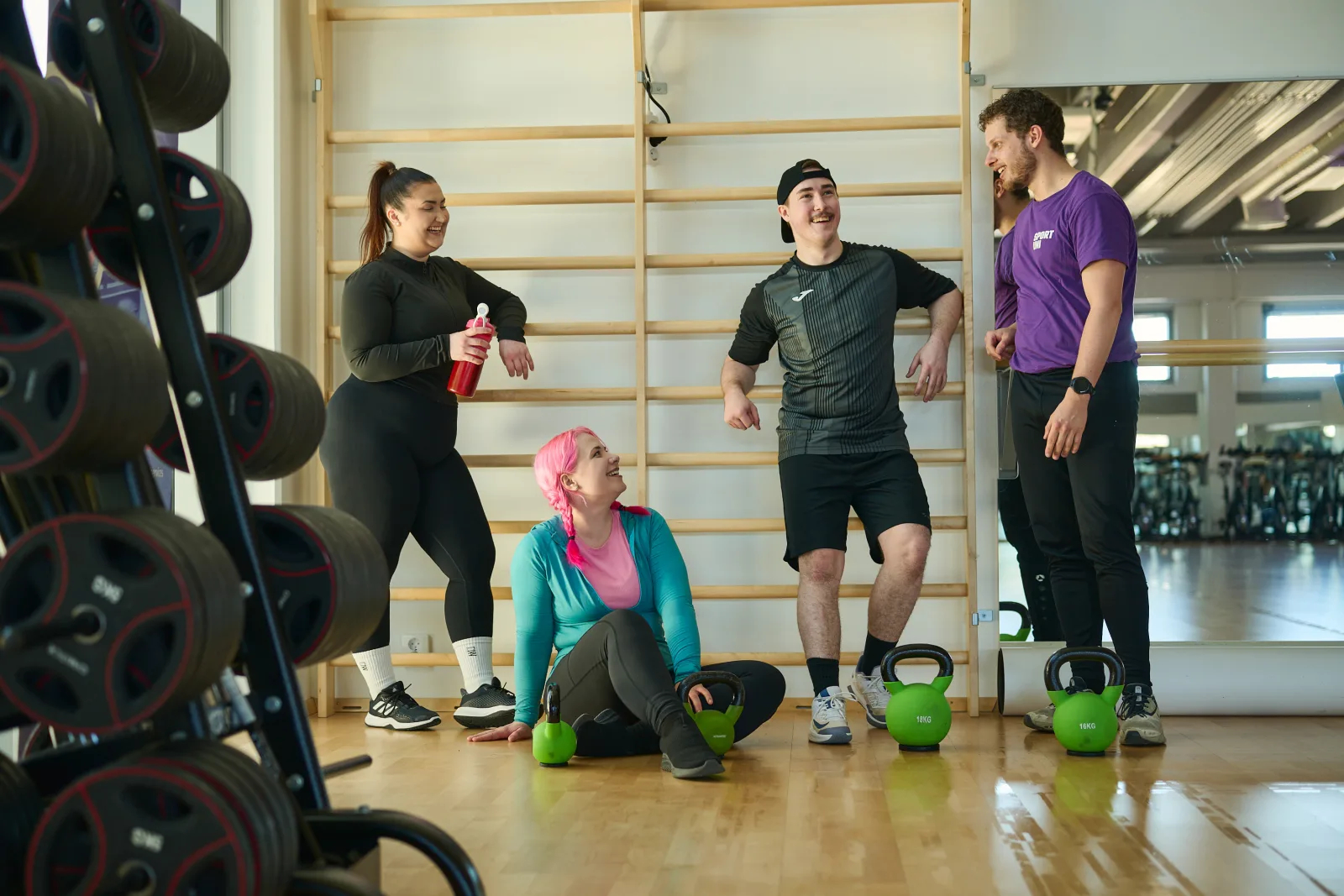 Opiskelijoita nojailee puolapuihin jumppasalissa.