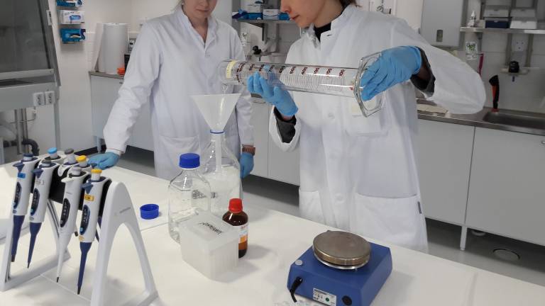 Valokuva molekyylibiologian laboratoriokurssilta, jossa nuoret tekemässä kemian työtä.