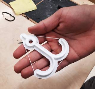 Koululaisen kädessä 3D tulostama ankkuri.