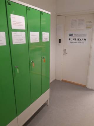 Seinäjoen yliopistokeskuksen EXAM-tilan ulkopuolella on vihreät säilytyskaapit päällysvaatteiden ja tavaroiden säilytystä varten.
