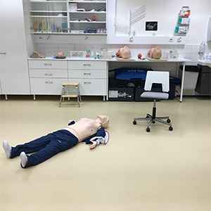 Practice doll lying on the floor.