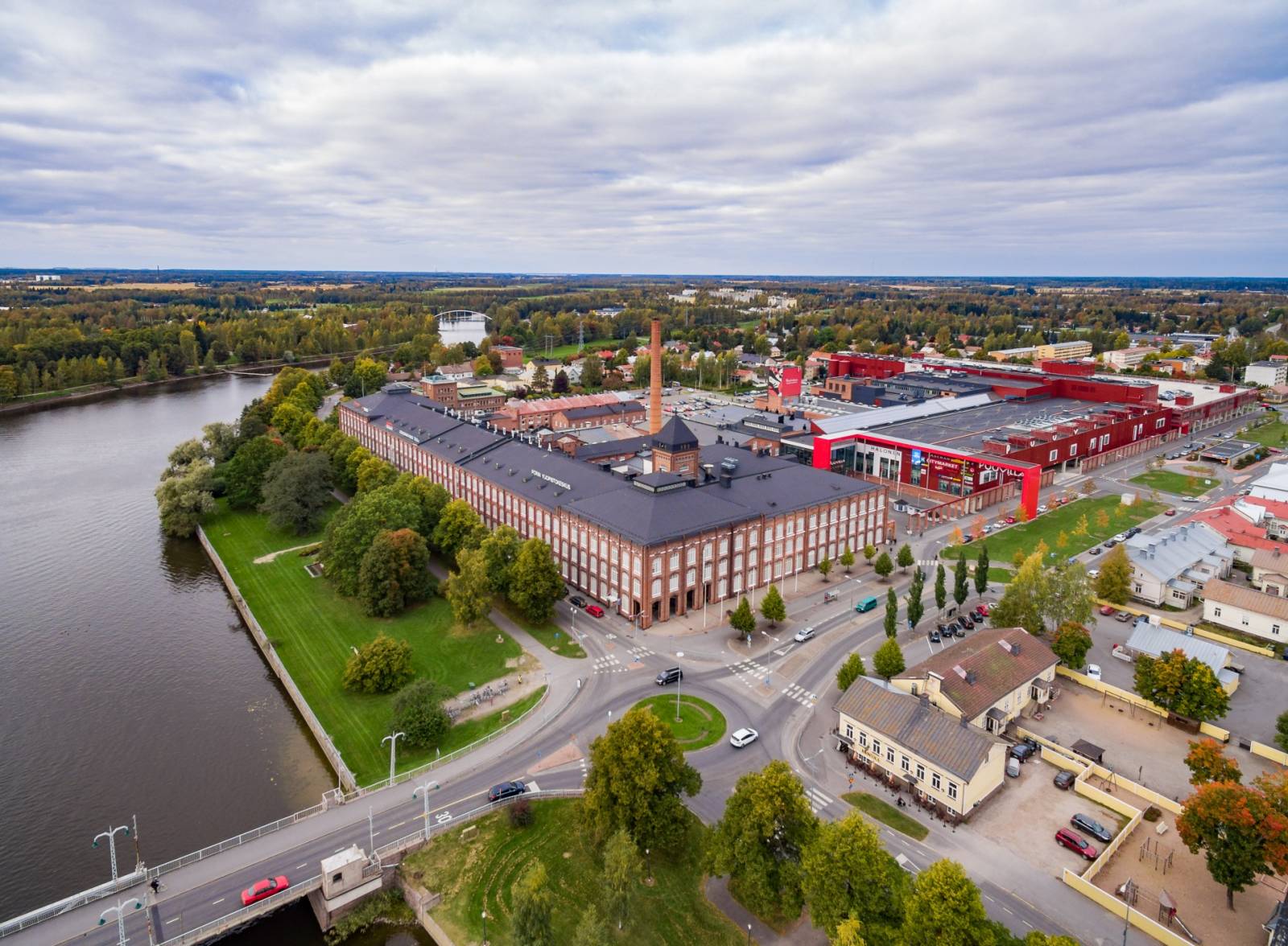 Ilmakuva Kokemäenjoen rannassa sijaitsevasta vanhasta puuvillatehtaan punatiilisestä korttelista, jossa Porin yliopistokeskus sijaitsee.