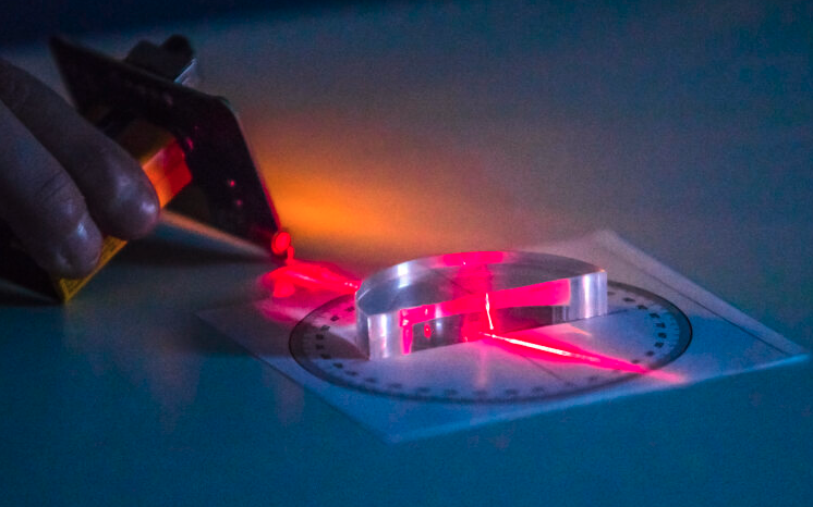 Laserin valonsäde kulkee prisman läpi.