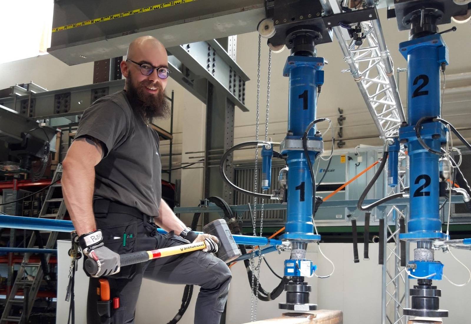 Aku Aspila standing with a hammer in hand in a test laboratory